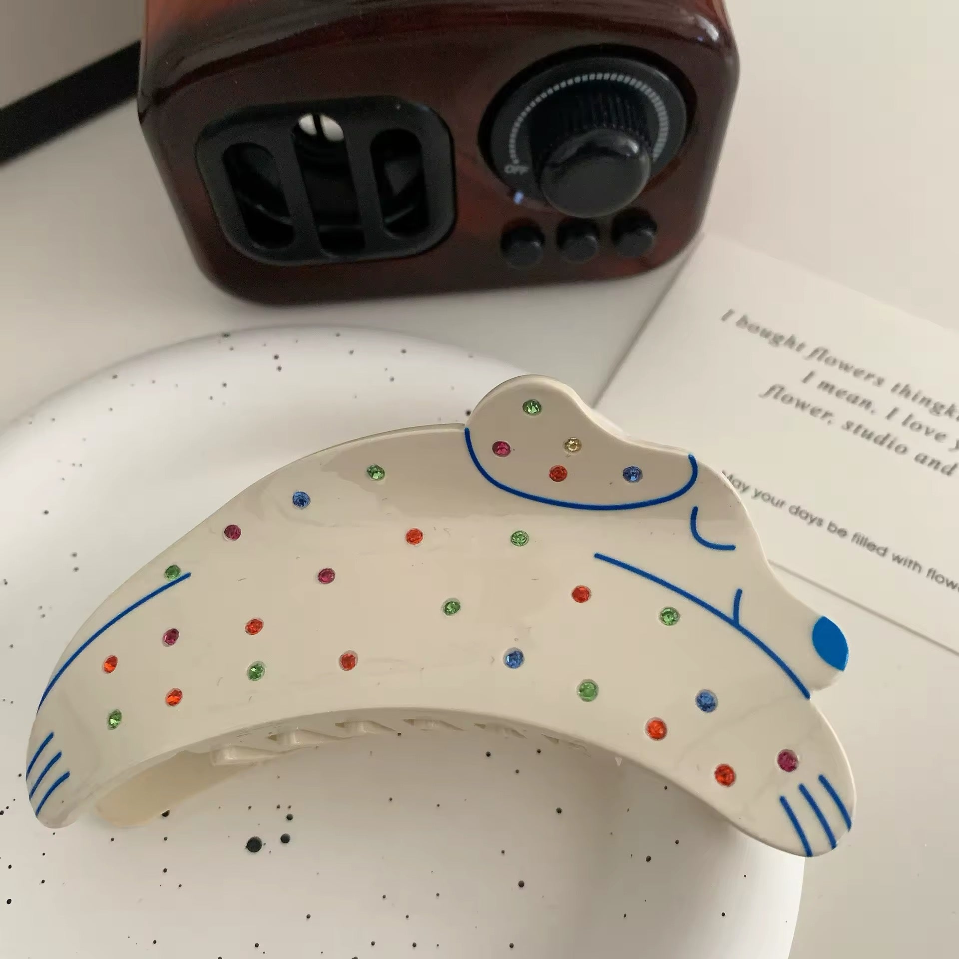 Top-down view of the hair claw clip resting on a pastel-colored background, highlighting its Y2K aesthetic appeal