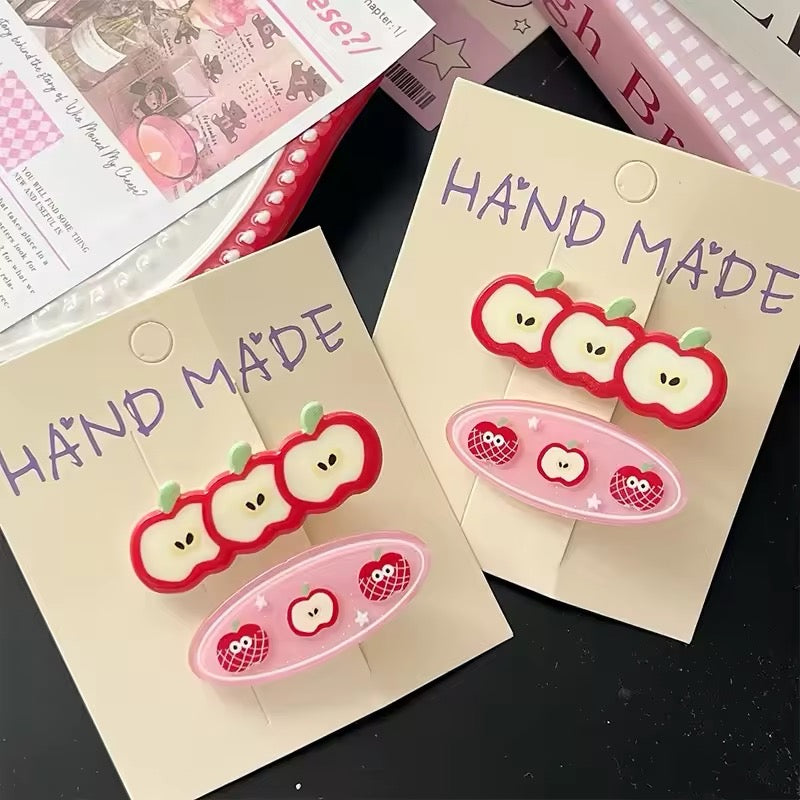 Two apple hairpins clipped on a card, styled for a giftable display option