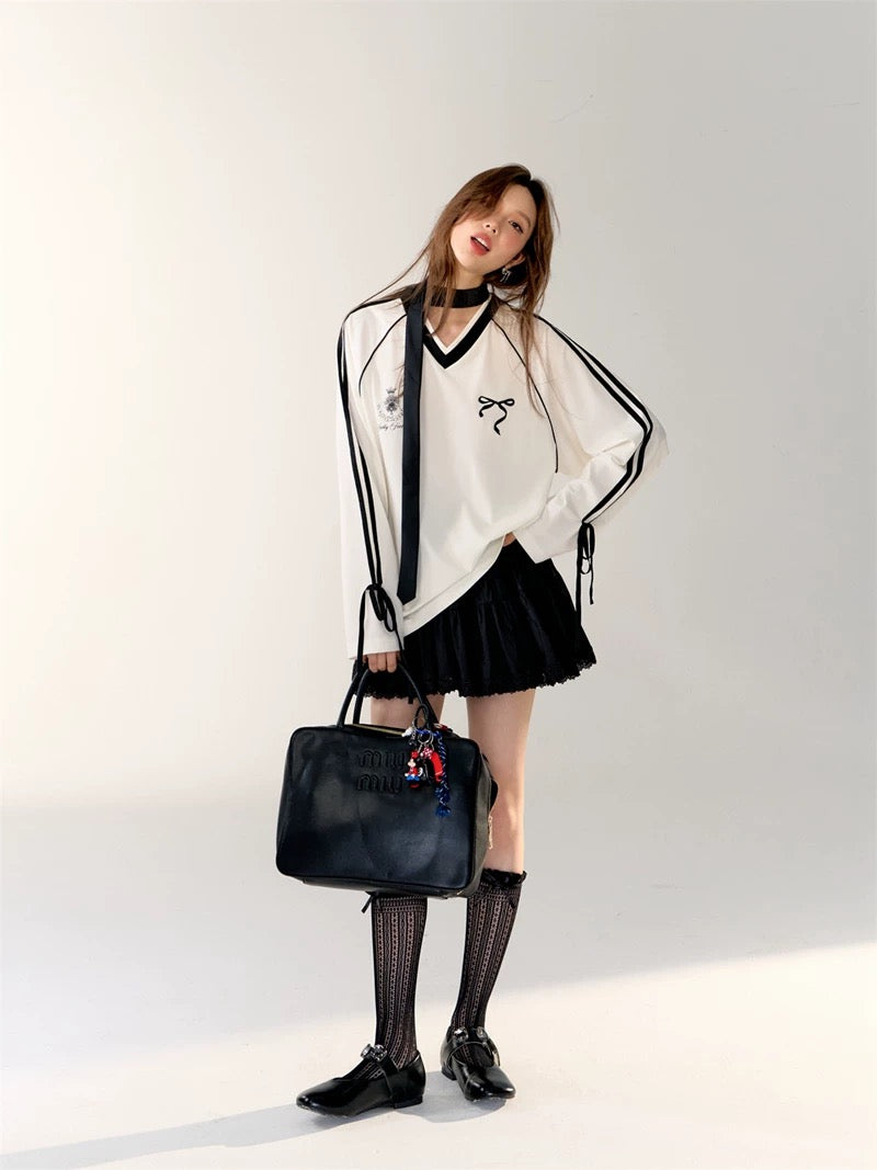 Side profile showing bow ties on sleeve cuffs of the Coquette Sporty Top.