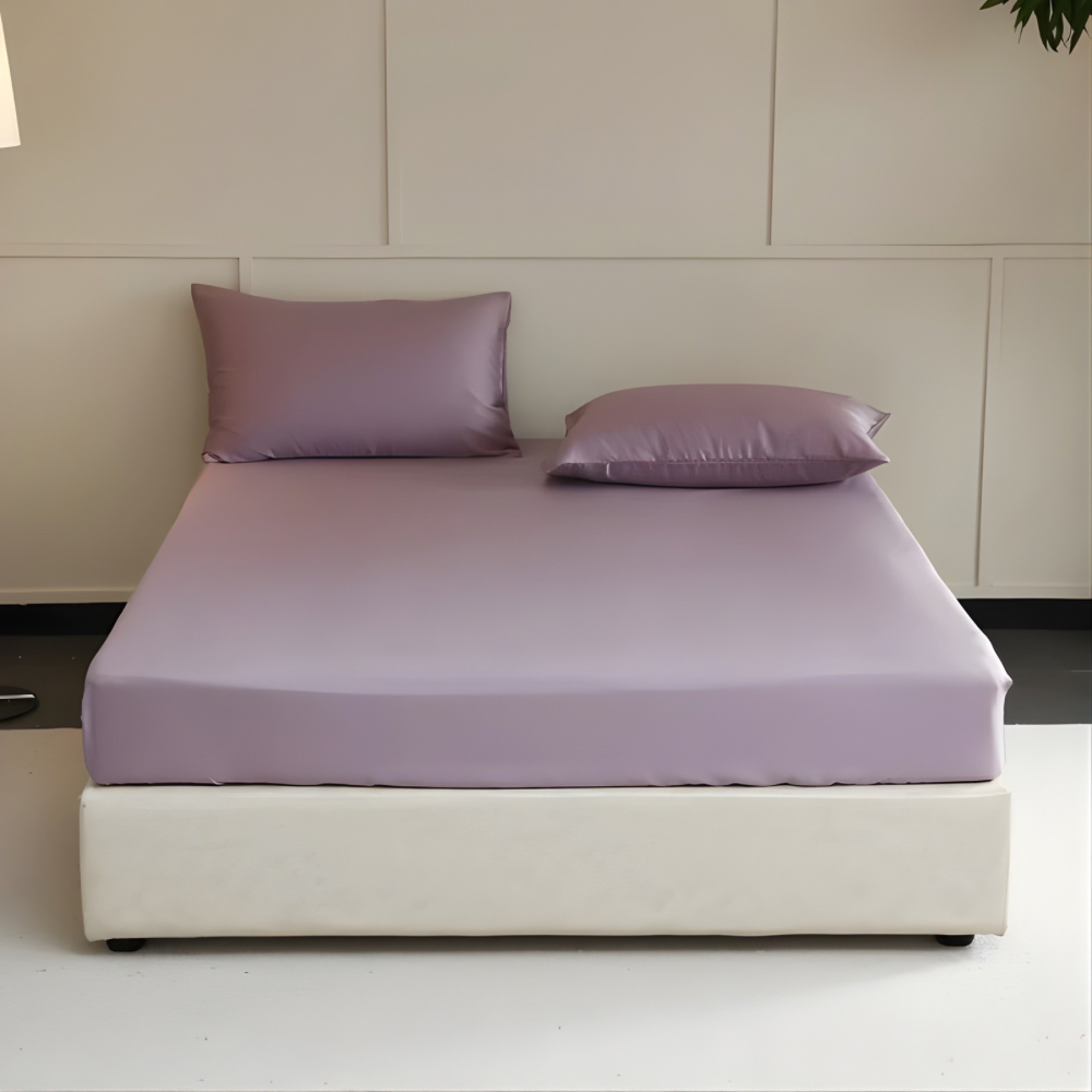 Bed with purple bedding and pillows in a minimalistic room.