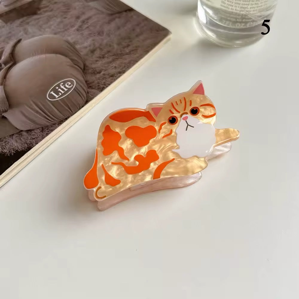 Close-up of the Siamese cartoon cat hair clip showing glossy acetate finish and bold blue eyes