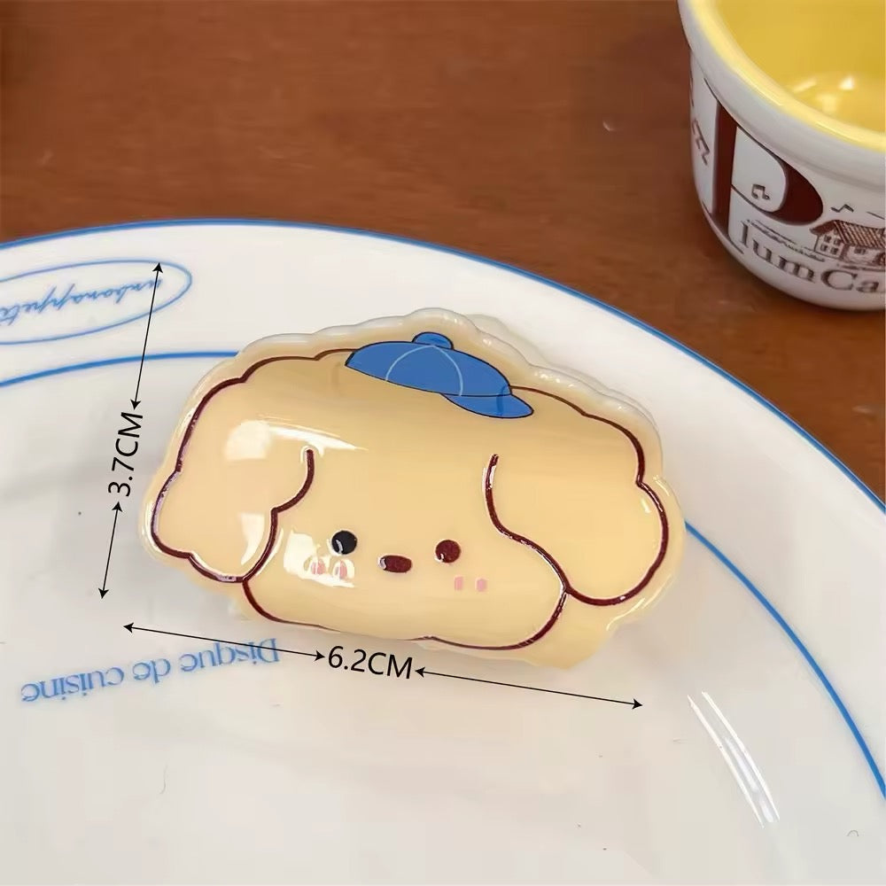 Group of kawaii acrylic claw clips on a beige plate, showing variety and size