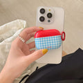 Flat lay of cute plaid AirPods case with pendant