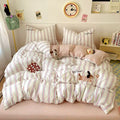 Bedding set with cartoon characters on a bed in a room with a clock and decor items.