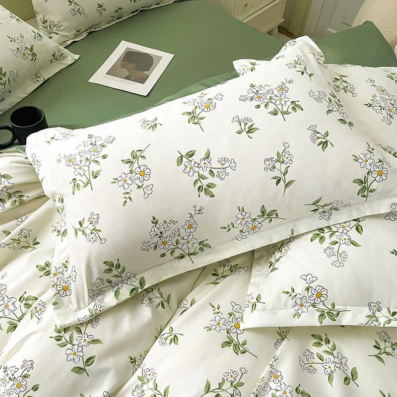 Floral patterned bedding set on a bed with a green headboard.
