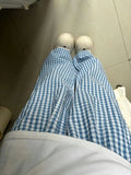Korean-inspired plaid trousers styled in minimalist bedroom scene with mirror reflection