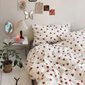 Bedroom with heart-patterned bedding, nightstand, and wall decorations.