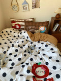 Polka dot comforter with cartoon character on a bed in a bedroom setting.
