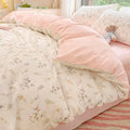 Soft pink floral bed linen set arranged on queen bed with natural light and cozy details
