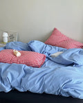 Korean minimalist bedroom featuring blue cotton duvet and plaid pillows