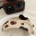 The spotted dog hair clip adorning a ponytail, emphasizing its versatility for various hairstyles