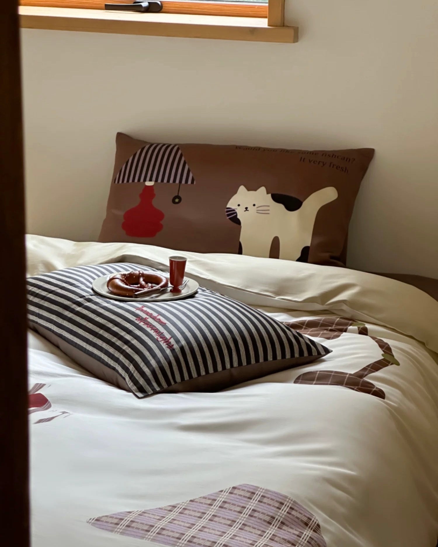 Bed with decorative pillows and a small table setup in a room.