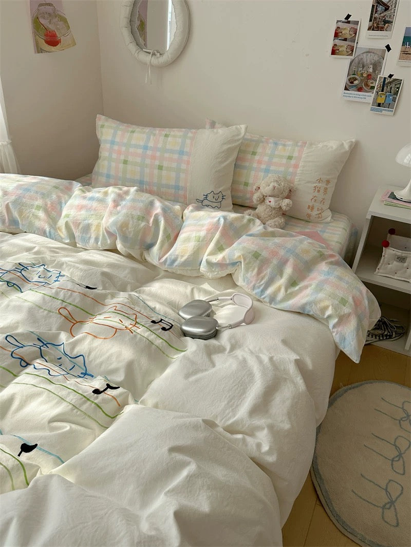 Bed with pastel-colored bedding and pillows in a room setting.