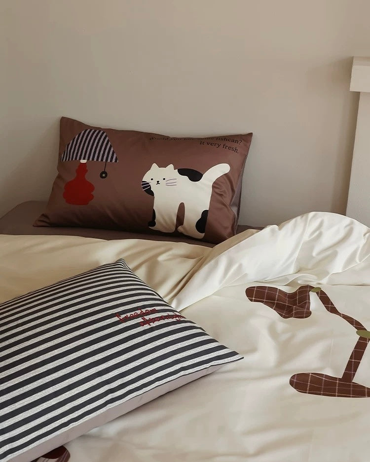Bed with cartoon-patterned bedding and pillows in a room setting.