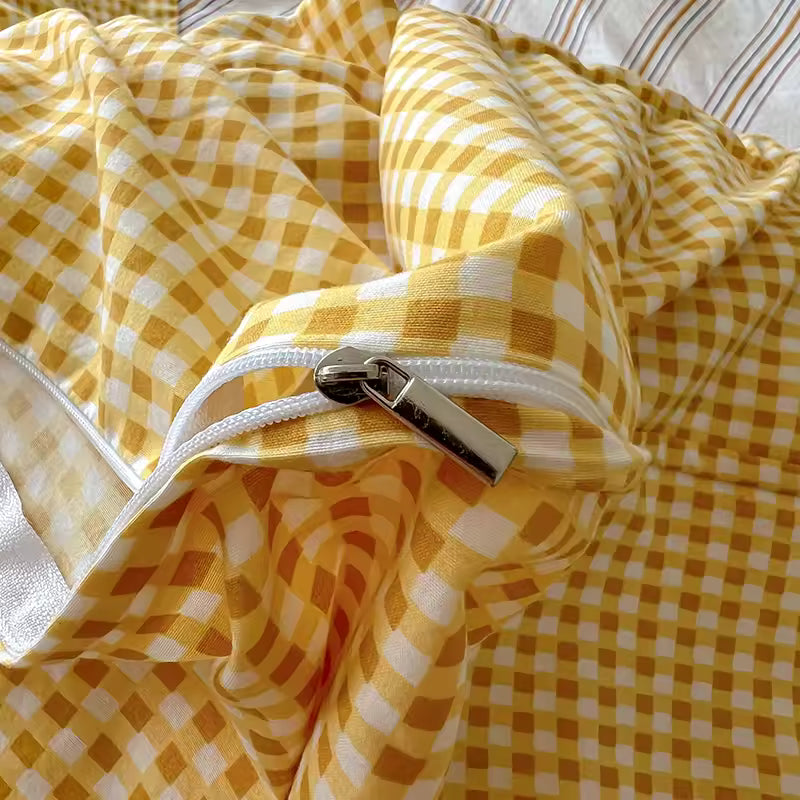 Yellow and white checkered blanket with a zipper on a bed.