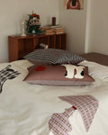 Decorative pillows on a bed with a wooden shelf in the background