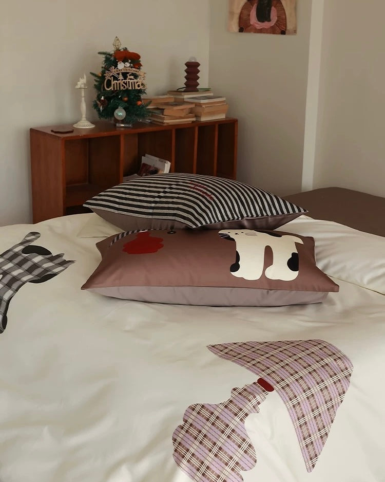 Decorative pillows on a bed with a wooden shelf in the background