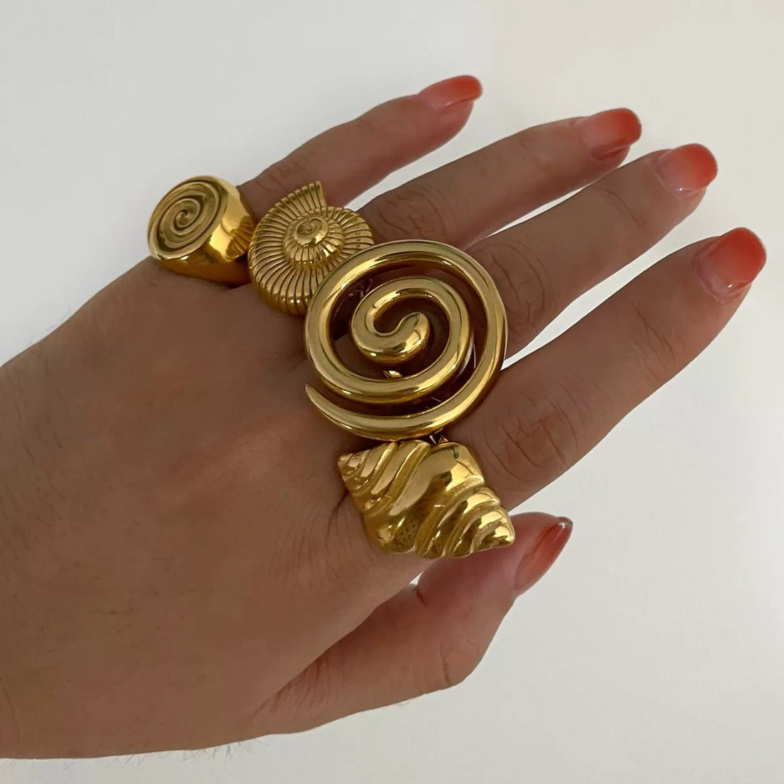 Gold conch ring with a glossy stainless steel spiral design
