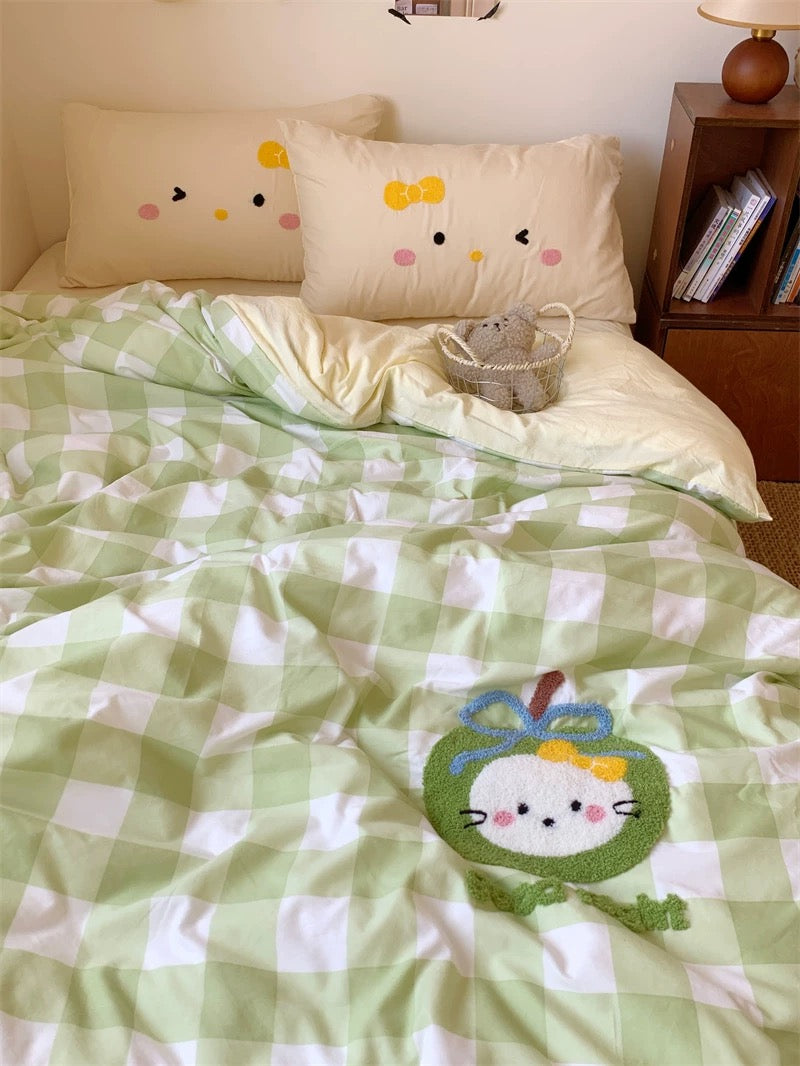 Bed with green and white checkered comforter featuring a cartoon character, next to a wooden nightstand.
