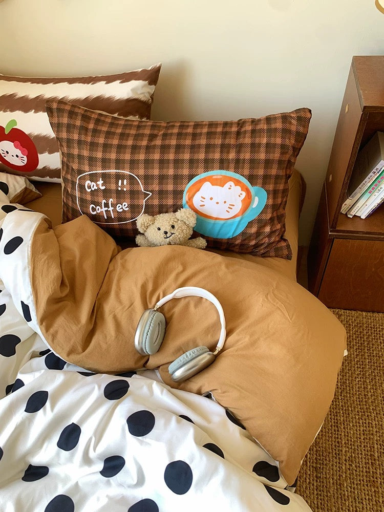 Bed with pillows, a blanket, and a teddy bear in a cozy room setting.
