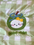 Plush toy shaped like a cartoon character on a green and white checkered background
