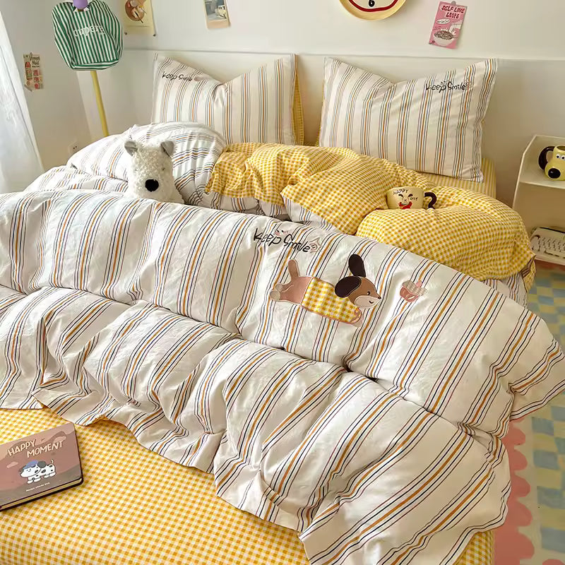 Striped bedding with cartoon characters on a bed in a room with yellow checkered pillows and a colorful rug.
