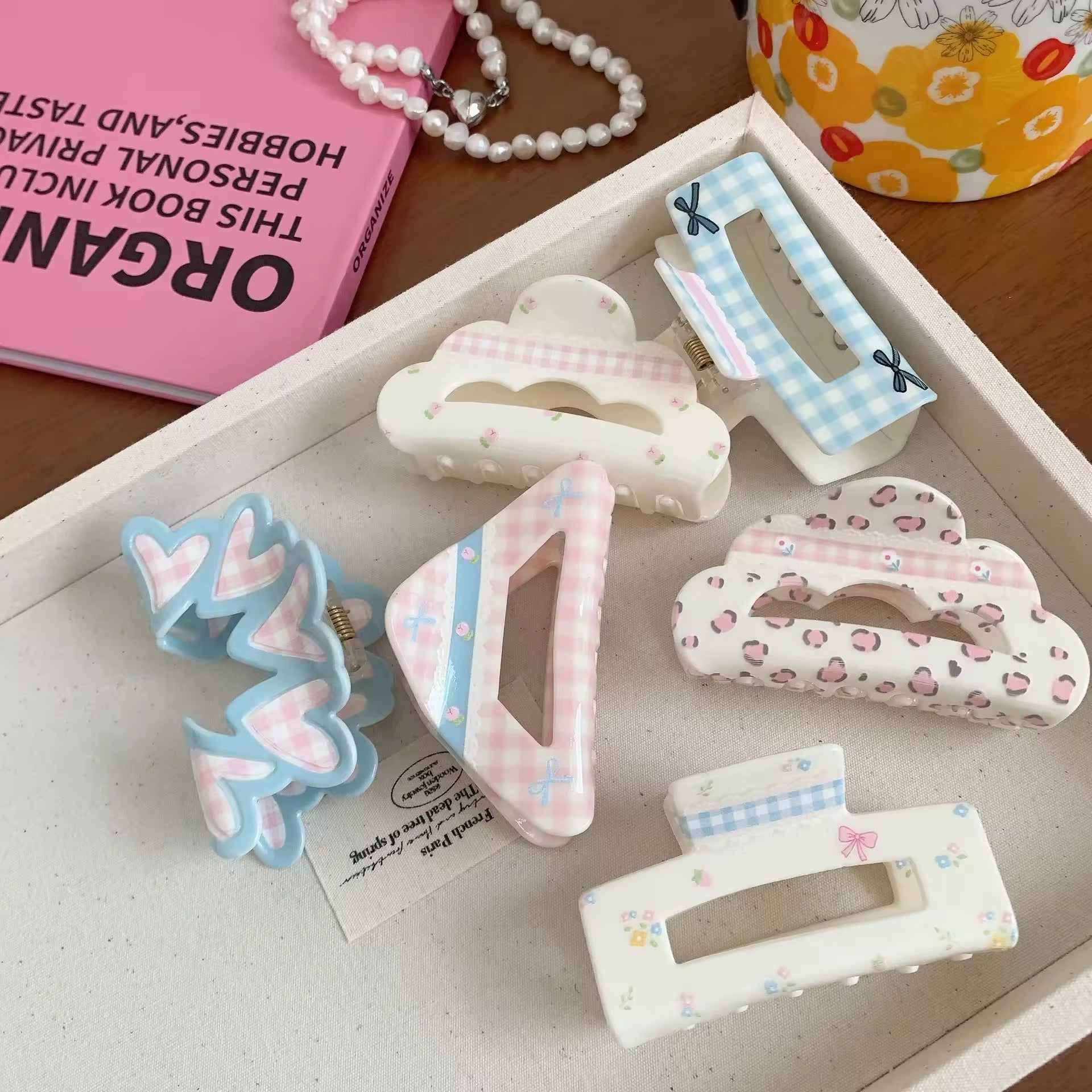 Hair claw with delicate pastel flowers on a creamy acrylic base, styled with dainty pearls