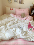 Bed with white bedding and pink checkered pillows in a bedroom setting.