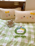 Children's bedroom with cartoon-themed pillows and a 'good night' patch on a checkered blanket.