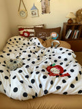 Polka dot comforter with cartoon character on a bed in a bedroom setting.