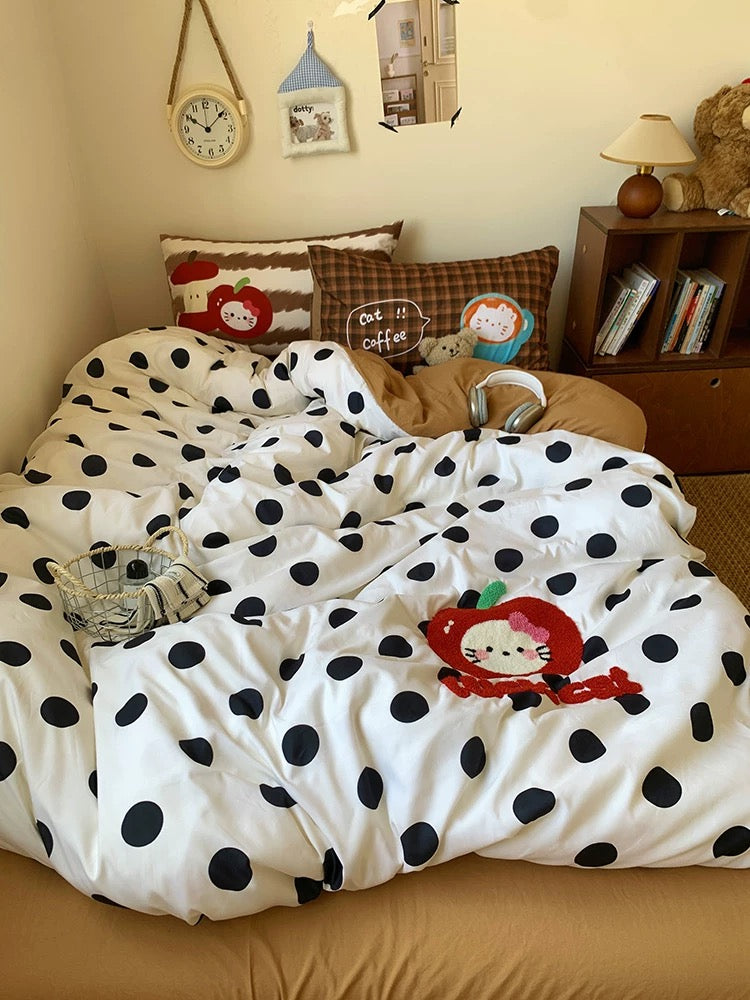 Polka dot comforter with cartoon character on a bed in a bedroom setting.