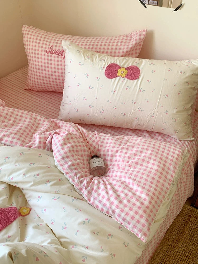 Children's bedroom with pink and white checkered bedding and pillows.