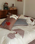 Bed with animal-themed pillows and a wooden shelf in the background
