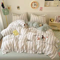 Striped bedding set on a bed with decorative pillows and a clock on the wall.