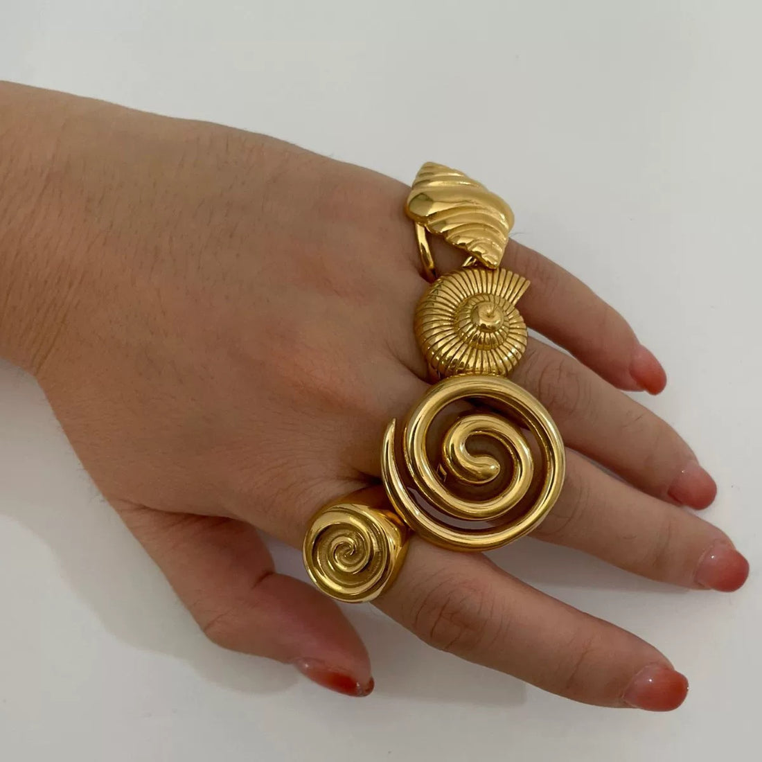 Gold conch ring with a glossy stainless steel spiral design