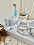 Cozy bedroom with a bed, pillows, and a lamp.