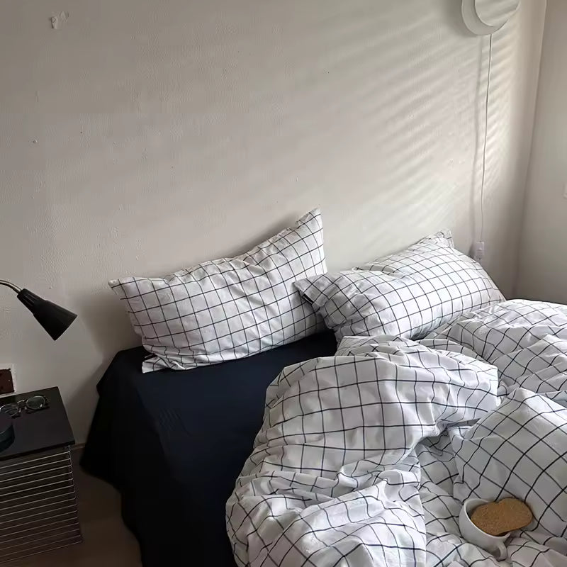 Bed with checkered bedding and pillows in a bedroom setting.