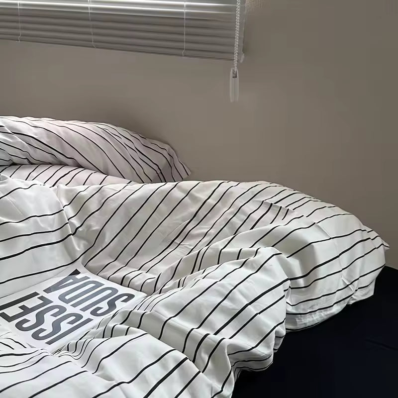 Striped bedding on a bed with a plain wall and window blinds in the background