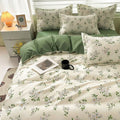 Floral bedding set on a bed with a nightstand and lamp in the background.