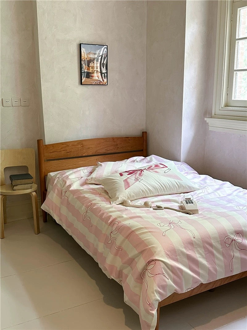 Bedroom with a wooden bed and pink and white checkered blanket.