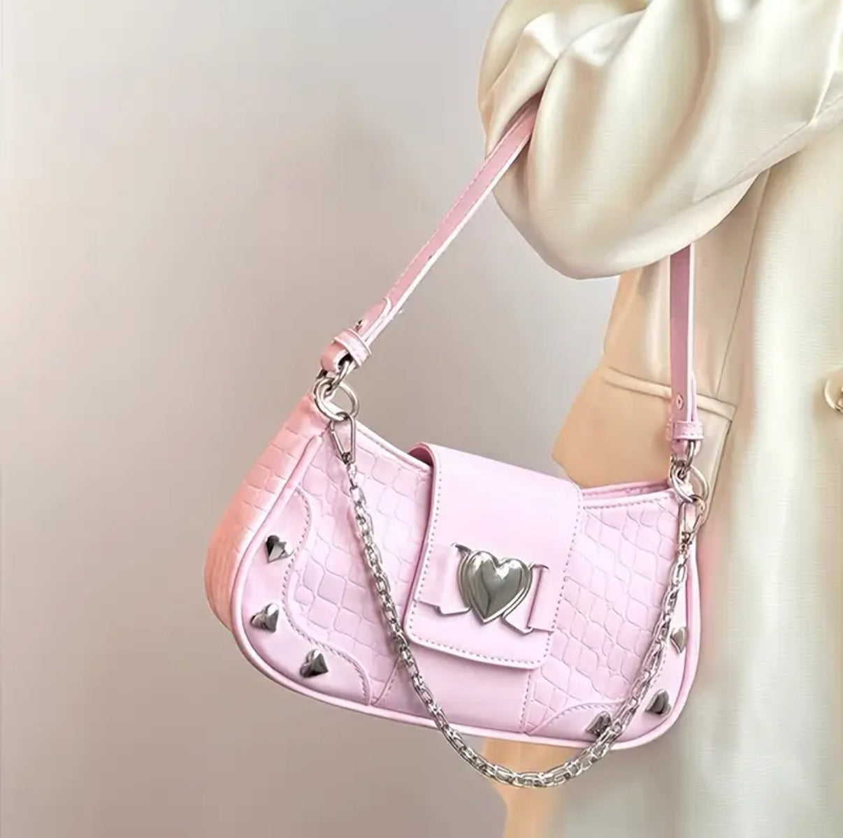 Pink handbag with edgy heart-shaped charm