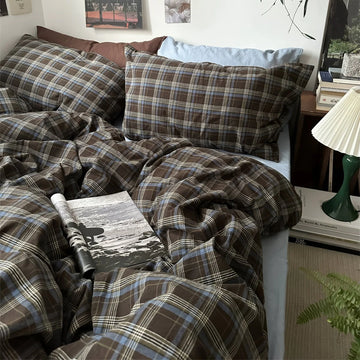 Bed with plaid bedding and pillows in a bedroom setting.
