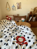 Children's bedroom with polka dot bedding featuring a Hello Kitty design, teddy bear, and books.