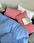 Blue washed cotton bedding set arranged casually on modern black bed
