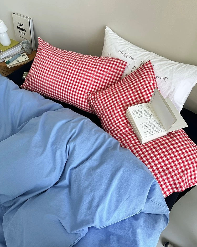 Blue washed cotton bedding set arranged casually on modern black bed