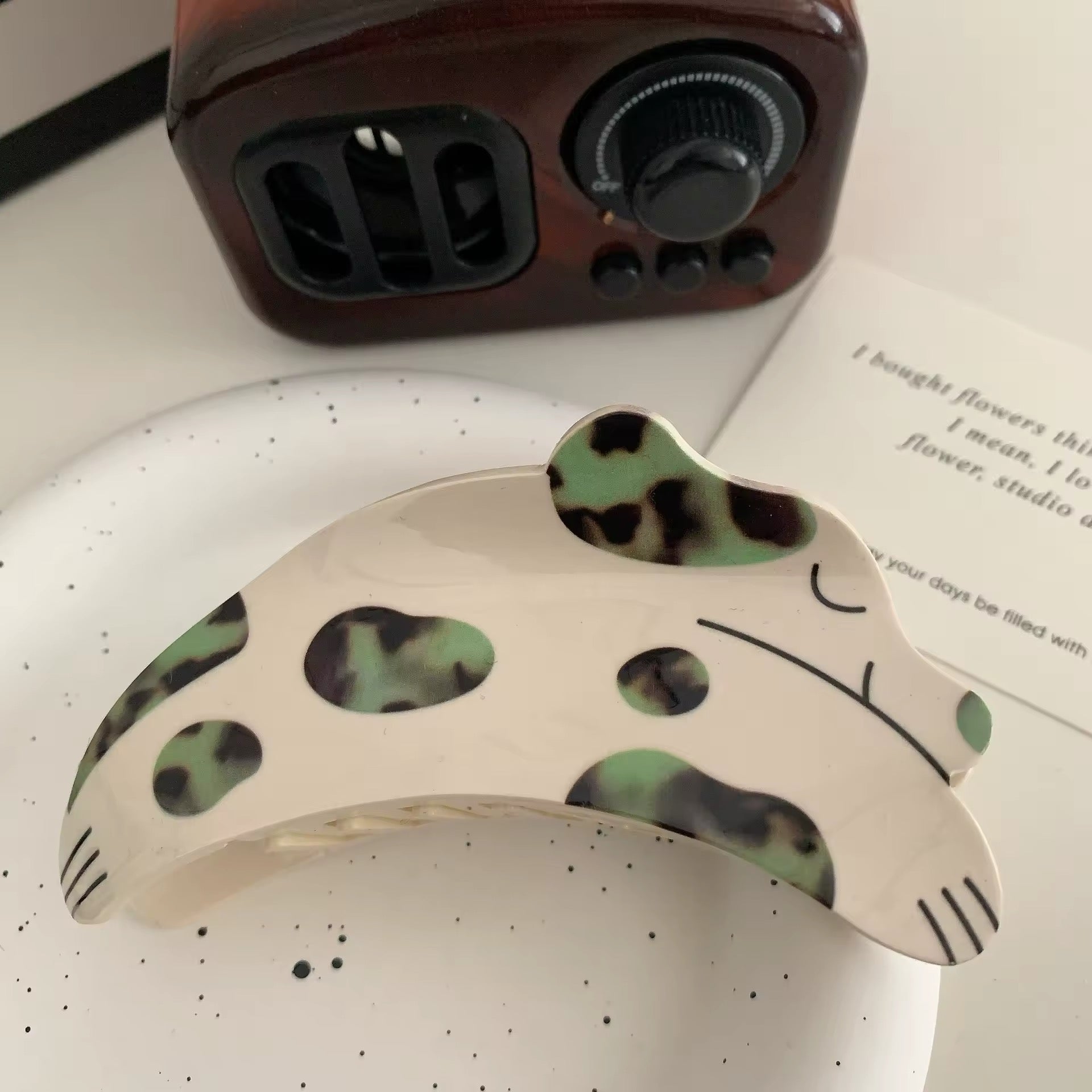 Side view of the acetate hair claw clip displaying the speckled pattern and sturdy construction