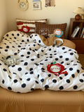 Polka dot comforter with cartoon character on a bed in a bedroom setting