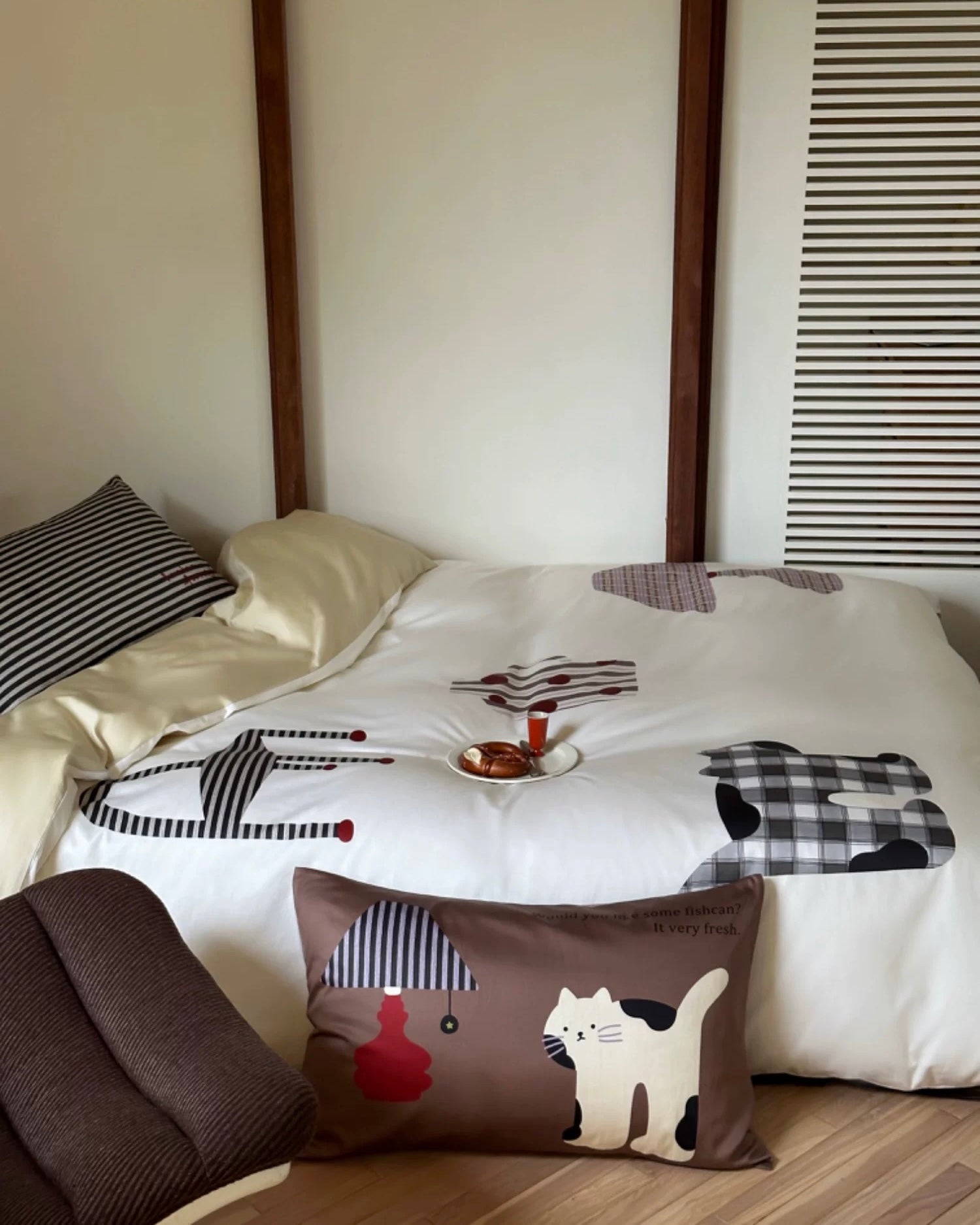 Bed with cartoon-patterned bedding and pillows in a room setting.
