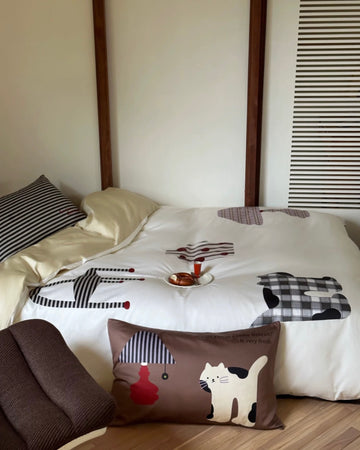 Bed with cartoon-patterned bedding and pillows in a room setting.