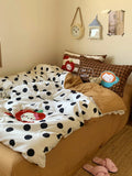 Bed with polka dot comforter and pillows in a cozy bedroom setting.